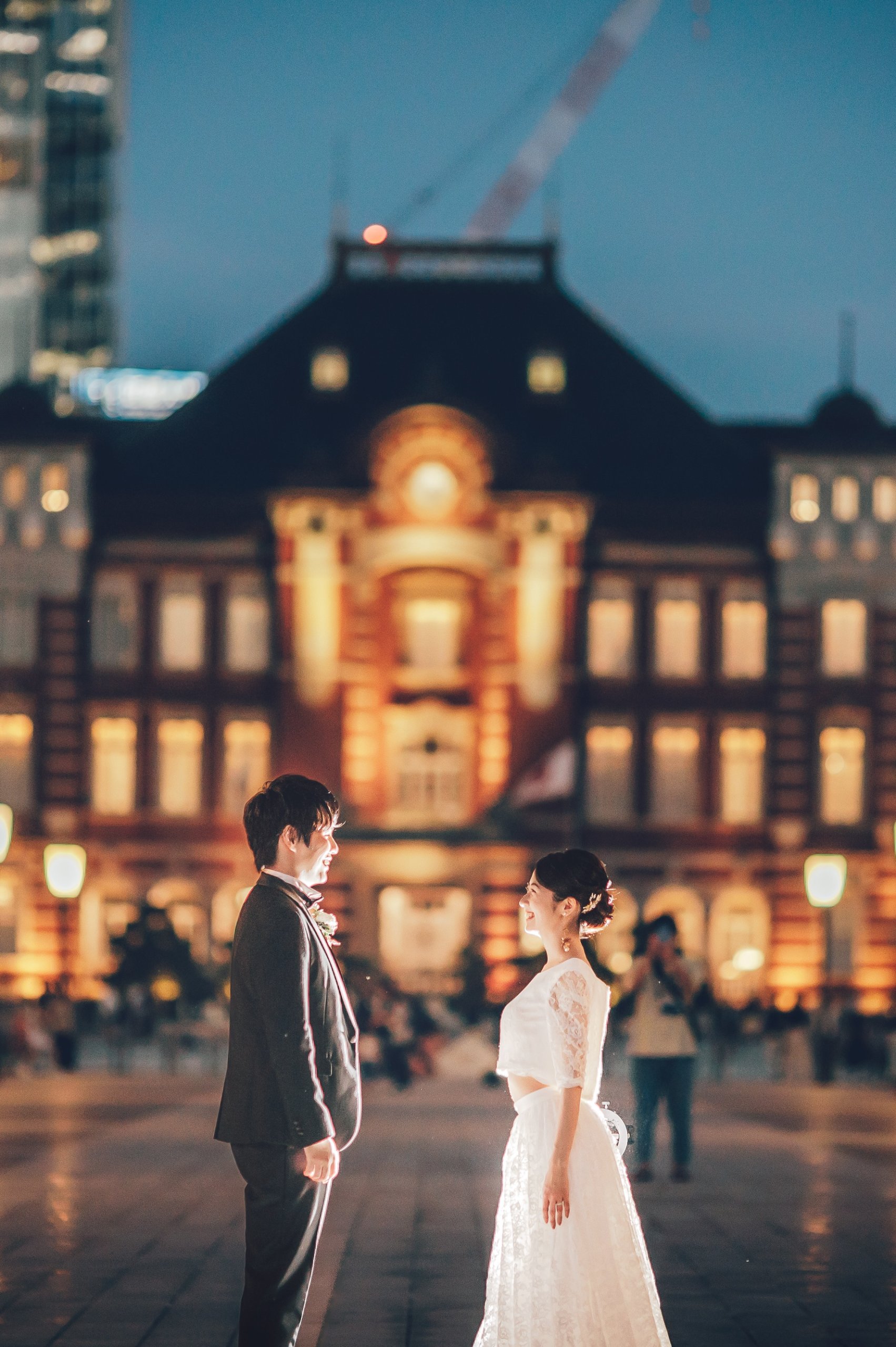 東京駅でドレスとタキシードを着て向かい合う夫婦