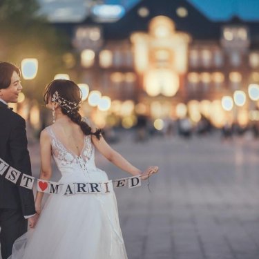 ガーランドを持った新郎新婦の後ろ姿