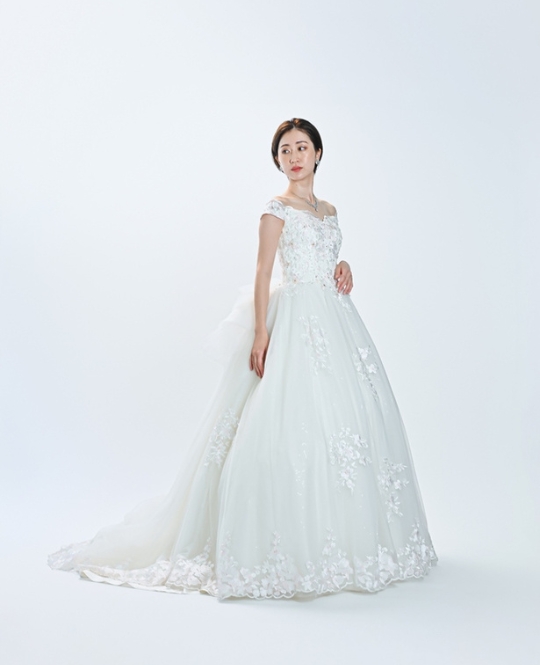 プリンセスライン（TR12）：繊細な刺繍が施されたプリンセスラインのドレスは、洗練された華やかさが際立つ一着。バックスタイルには大きなリボンがあしらわれており、後ろ姿まで抜かりなく愛らしさを演出します。可憐さと華やかさを兼ね備えたデザインは、特別な一日をいっそう輝かせてくれます。