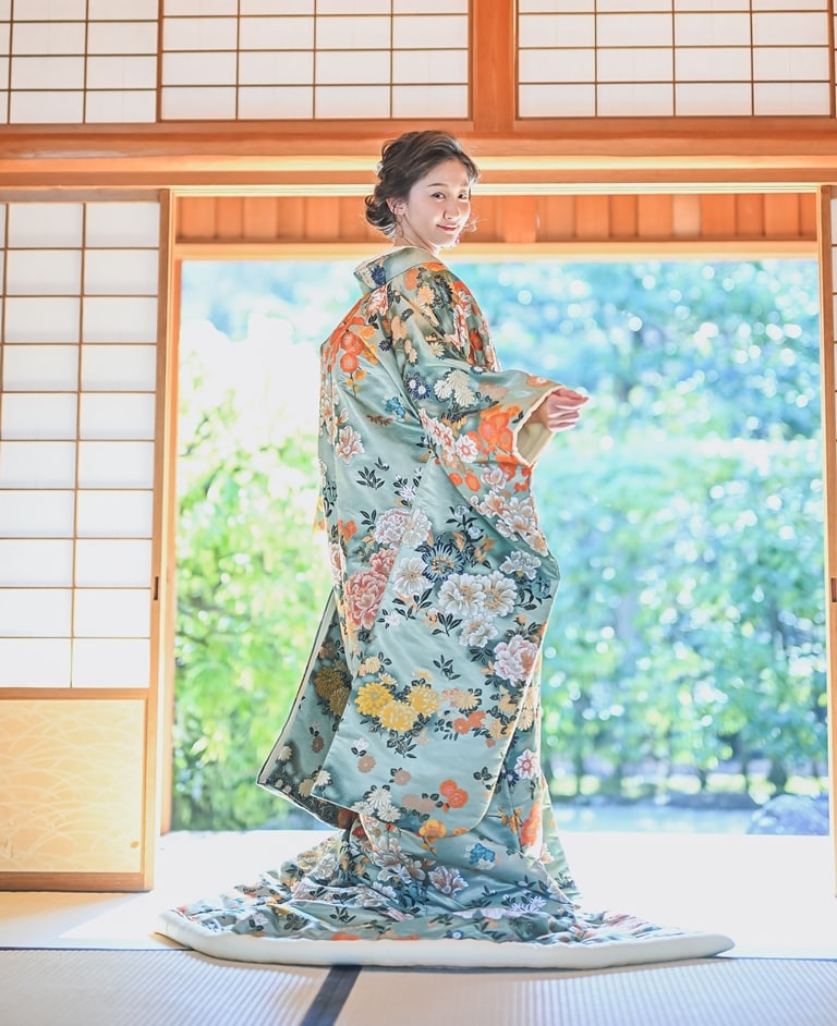 花洛煌妃（NMOS05）：凛とした淡いグリーンと、華やかな花々が特徴のカラフルな色打掛。水辺で健気に咲き揃う姿に爽やかさを感じるお着物は、お庭での撮影にぴったりです。