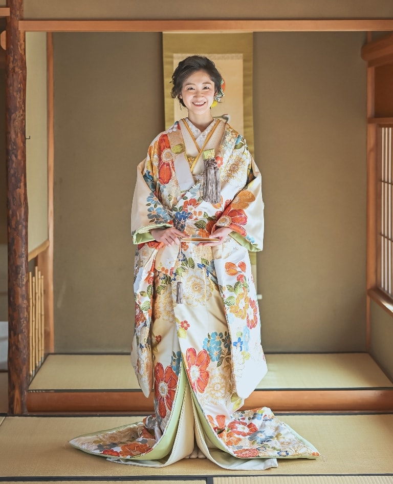 舞花満開（TMOS09）：満開のオレンジやブルーのお花が特徴の華やかな色打掛。水墨画のような手法で描かれた花々は、明るさや風格をより引き立てています。