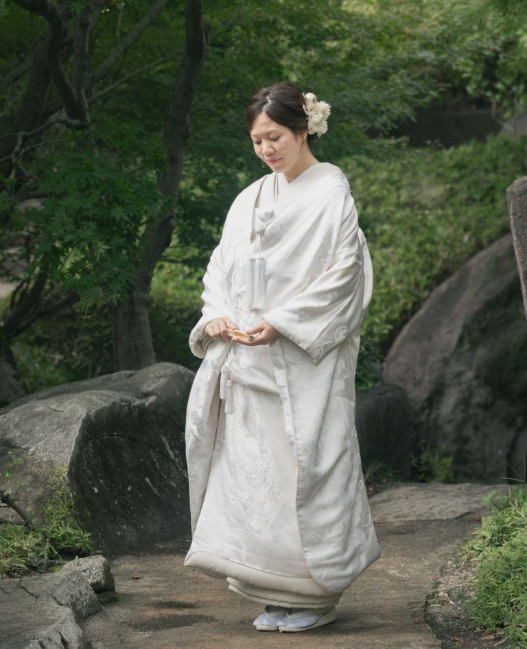 珍しい花の扇子に繊細なリボンがあしらわれた意匠が印象的な白無垢。吉祥の象徴である松模様が全体に優雅に織り込まれ、華やかさと気品を併せ持つ一着です。