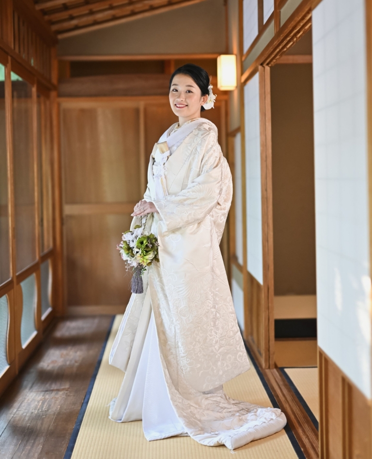 上品な光沢をまとったオフホワイトの白無垢。柔らかく艶めく生地が花嫁の肌を美しく引き立て、清楚で気品あふれる佇まいを演出します。
