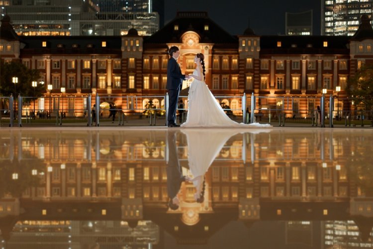 ライトアップされた東京駅を背景に、ウェディングドレス姿のおふたりが幻想的に佇むナイトフォトウェディング