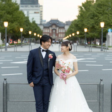 行幸通りのいちょう並木と東京駅を背景に、ブーケを持つ花嫁と見つめ合うタキシードの新郎。丸の内で撮る洋装ロケーションフォト