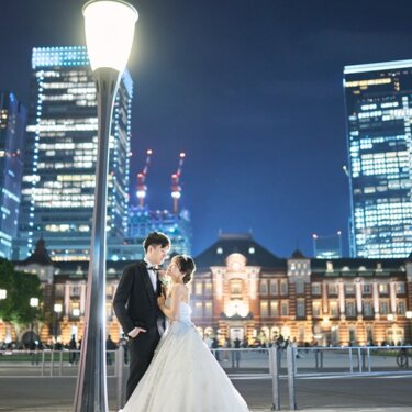 東京駅丸の内駅舎を背景に、ブーケの香りをそっと楽しむウェディングドレスの花嫁。昼の東京駅前撮り