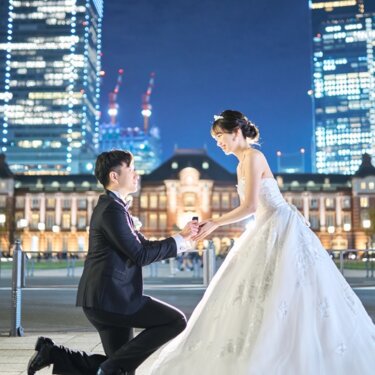 東京駅丸の内駅舎を背景に寄り添う新郎新婦。ふわりと広がるドレスの裾が印象的な東京駅フォトウェディング