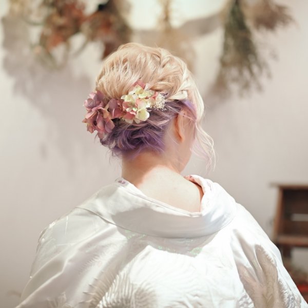 淡い紫のインナーカラーとパールの髪飾り、ドライフラワーを飾った後ろ姿ヘアスタイル。