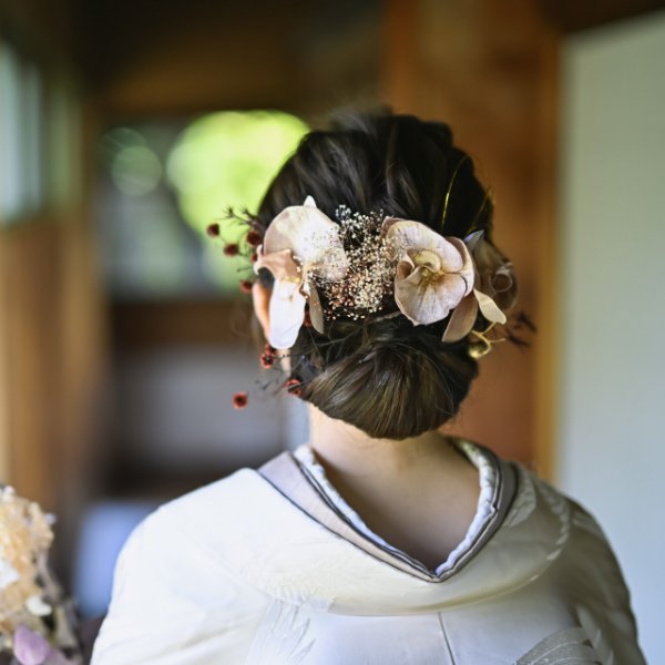 赤いあしらいと金の実をあしらった和のヘアアクセサリー、和装の後ろ姿。